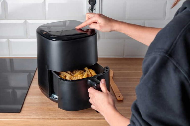 Une jeune femme qui utilise un Airfryer pour cuisiner plus sainement.