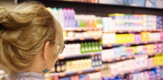 Une femme faisant ses courses, influencée par les publicités pour des aliments ultra-transformés.