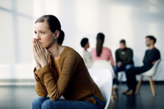 Anxiété sociale symtômes causes traitements troubles maladie angoisse ma sante Une femme s’isole de ses collègues de travail, en raison d’une forte anxiété sociale.