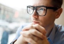 Troubles de la vision : comment savoir si je suis astigmate ? Un homme qui porte des lunettes avec des verres toriques, destinés à corriger son astigmatisme.