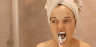 Faut-il se brosser les dents avant ou après le petit-déjeuner ? Une femme qui se brosse les dents avant le petit-déjeuner.