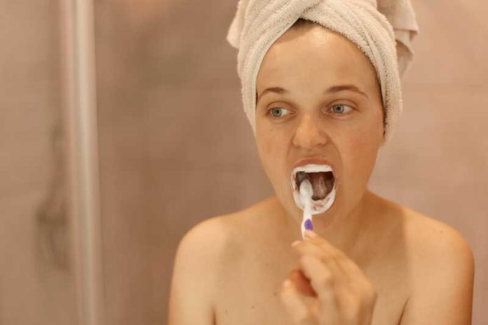 Faut-il se brosser les dents avant ou après le petit-déjeuner Ma Santé Une femme qui se brosse les dents avant le petit-déjeuner.