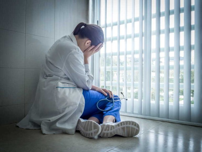 Une infirmière épuisée, fragilisée par des conditions de travail éprouvantes.