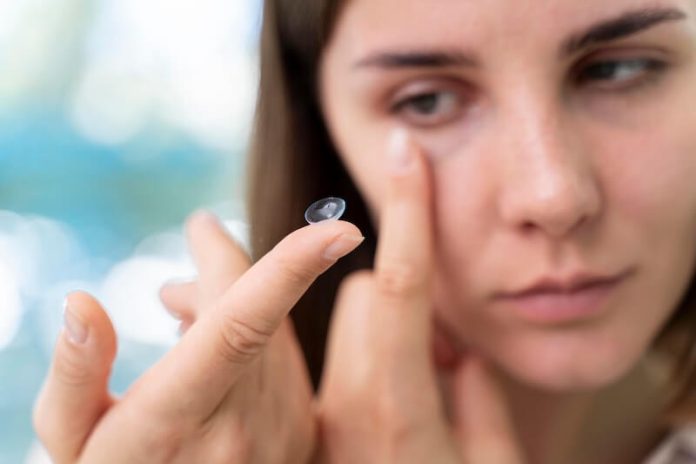Lentilles contact vision vue ophtalmologue myopie hypermétropie astigmatisme presbytie ma sante Une femme appliquant ses lentilles de contact, atteinte d’un trouble oculaire.