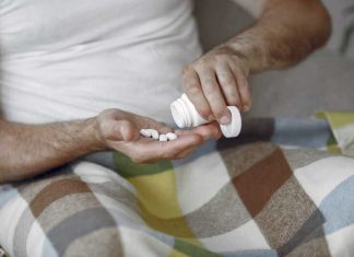 Un homme prenant des médicaments pour soulager les symptômes liés à la maladie de Charcot.