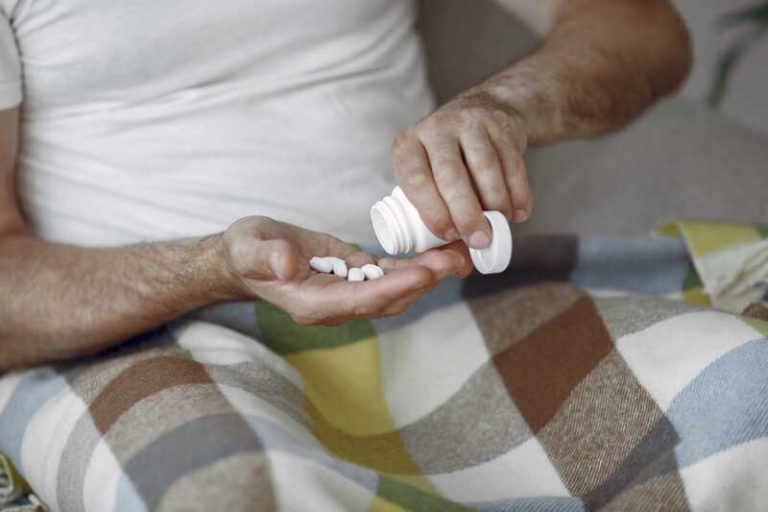 Un homme prenant des médicaments pour soulager les symptômes liés à la maladie de Charcot.