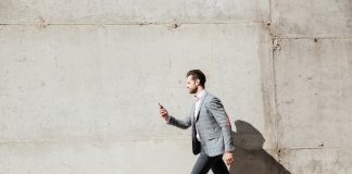 Un homme marche rapidement en ville, sur le chemin de son travail, profitant des bienfaits de cette activité sur sa santé cardiovasculaire.