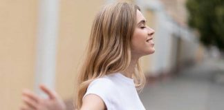 Moins on en dit, mieux on se porte : se taire rend-il vraiment plus heureux ? Une femme heureuse d’avoir appris à se taire pour préserver sa santé mentale.