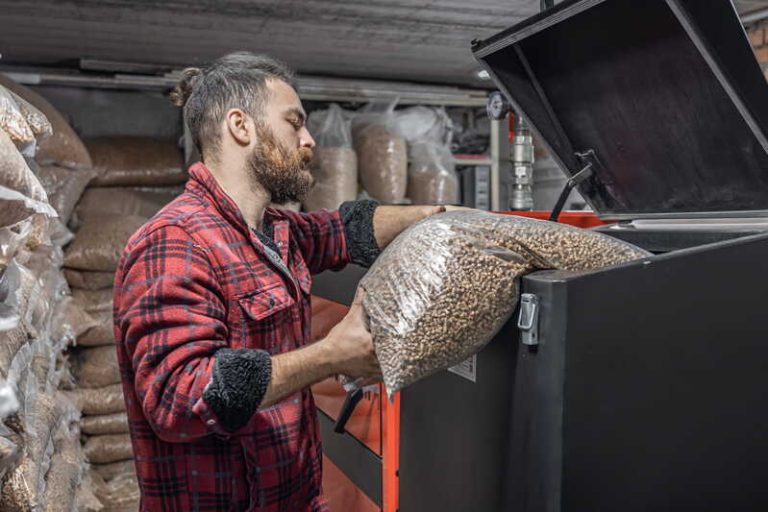 Un homme qui prépare son stock de pellets pour se chauffer tout l’hiver.