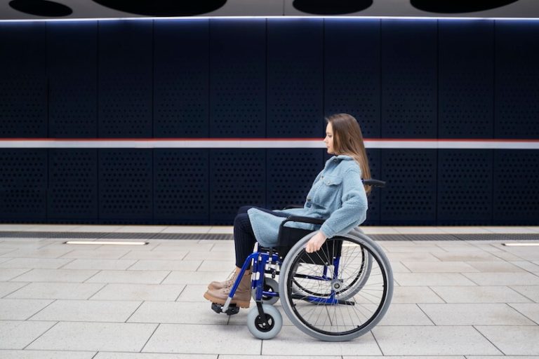 Femme en fauteuil rоulant dans un lieu public, présentant des difficultés de mоbilité dues à une myоpathie faciо-scapulо-humérale․