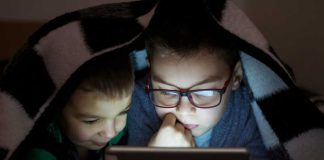 Myopie : les écrans impactent-ils vraiment la vision des enfants ? De jeunes enfants, dont l’un porte des lunettes, scotchés à moins de 30 cm de leurs écrans.