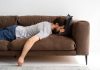 Un jeune homme paresseux qui préfère ne rien faire sur son canapé.