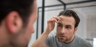 Un jeune homme qui scrute son visage dans le miroir parce qu’il a peur de vieillir.
