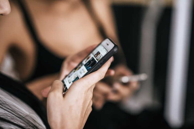 Une femme scrolle intensément sur ses réseaux sociaux, absorbée par un flot continu de contenus qui captent toute son attention.
