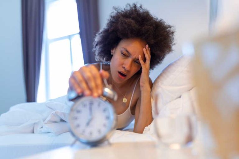 Une femme ayant dormi huit heures cette nuit, mais qui se réveille pourtant épuisée.