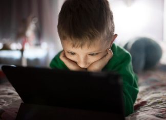 Un enfant trop jeune regarde un écran.