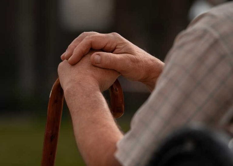 Un homme atteint de la maladie de Parkinson qui essaie de tenir correctement sa canne.