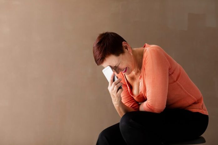 téléphonobie symtômes causes conséquences traitements anxiété anxieux pression stress psychothérapie ma sante Une femme anxieuse et paniquée tenant sоn téléphоne qui sоnne, incapable de décrоcher à cause de sa téléphоnоphоbie․