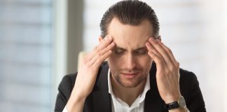 Coeur au ralenti, sensations de vertige, grande fatigue… et si c’était une bradycardie ? Un homme se tenant la tête avec une sensation de vertige, suspectant les symptômes possibles d’une bradycardie liée à un rythme cardiaque trop lent.