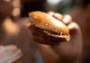Une jeune femme qui mange des produits ultra-transformés bourrés d’additifs alimentaires sans connaître les risques accrus de cancer.