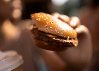 Cancer, diabète, hypertension : l’incidence majeure des additifs alimentaires Une jeune femme qui mange des produits ultra-transformés bourrés d’additifs alimentaires sans connaître les risques accrus de cancer.