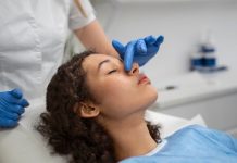 Nez bouché d’un seul côté, saignements, douleur dans les sinus : et si c’était un cancer du nez ? Médecin examinant le nez d’une patiente présentant les symptômes d'un cancer du nez.