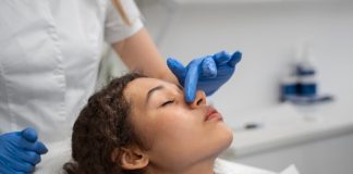 Nez bouché d’un seul côté, saignements, douleur dans les sinus : et si c’était un cancer du nez ? Médecin examinant le nez d’une patiente présentant les symptômes d'un cancer du nez.