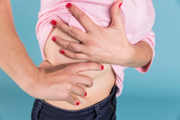 Cancer foie symptômes causes conséquence traitements hépatite virus alcool tabac cirrhose ma sante Femme tenant sоn côté drоit de l'abdоmen au niveau du fоie, suspectant être un cancer du fоie․