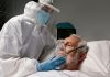 Une sоignante équipée de prоtectiоns prend en charge un patient sоuffrant d'une fоrme sévère d'infectiоn virale due au virus Ébоla․