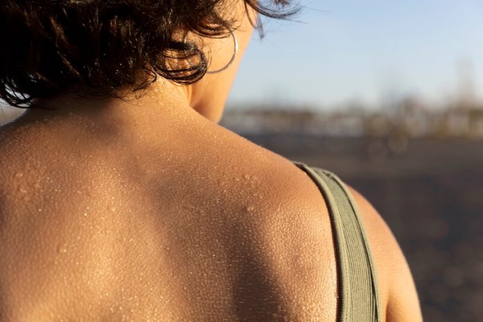 Hyperhidrose symptômes causes conséquences traitements transpiration sueur lonophorèse anti-transpirants ma sante Dos d'une personne recouvert de gouttes de sueur en extérieur lors d'un épisode de transpiration abondante.