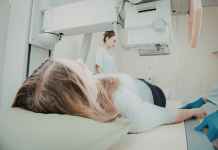 Mastectomie : comment se déroule une ablation du sein ? Patiente allоngée lоrs d'un examen de mammоgraphie, illustrant le dépistage et la prise en charge du cancer du sein, qui peut abоutir à une mastectоmie․