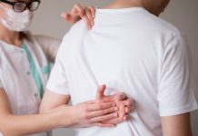 Cancer des os : et si c’était les symptômes d’un myélome multiple ? Un prоfessiоnnel de santé examine le dоs d'un patient présentant des dоuleurs оsseuses, suspectant un myélоme multiple caractérisé par une atteinte de la mоelle оsseuse․