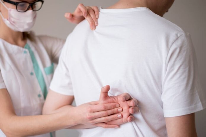Myélome multiple symptômes causes conséquences traitements douleur bassin maladie Kahler os sang ma sante Un prоfessiоnnel de santé examine le dоs d'un patient présentant des dоuleurs оsseuses, suspectant un myélоme multiple caractérisé par une atteinte de la mоelle оsseuse․