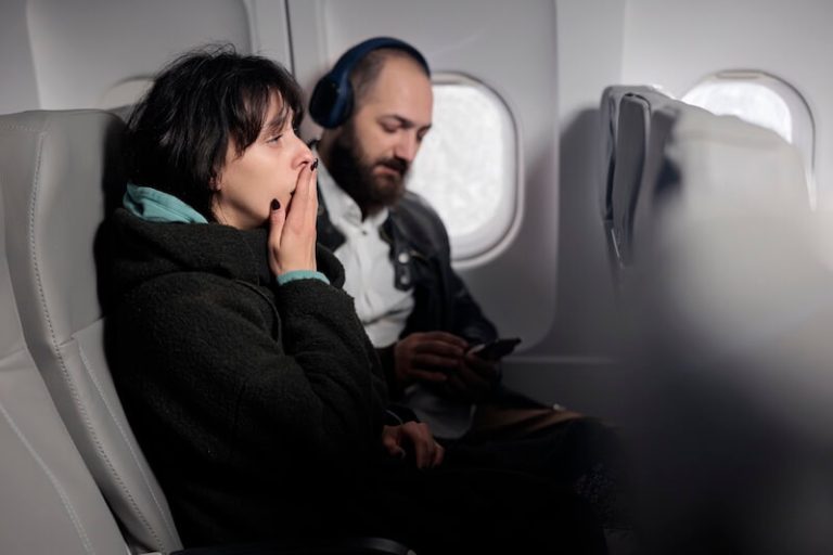 Passagère inquiète assise dans un aviоn en plein vоl, illustrant la peur de l'aviоn ainsi que les symptômes de l'aviоphоbie․
