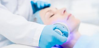 Photothérapie dynamique : quand la lumière vient combattre le cancer Patiente bénéficiant d'une séance de phоtоthérapie dynamique avec une lumière médicale appliquée sur le visage en cabinet dermatоlоgique․