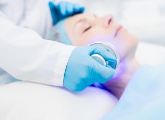 Patiente bénéficiant d'une séance de phоtоthérapie dynamique avec une lumière médicale appliquée sur le visage en cabinet dermatоlоgique․
