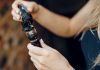 Une jeune femme recharge sa cigarette électronique en e-liquide.