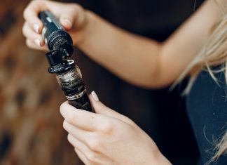 Quels e-liquides choisir lorsqu’on est allergique ? Une jeune femme recharge sa cigarette électronique en e-liquide.