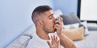 Asthme et canicule : pourquoi les crises augmentent-elles lors des fortes chaleurs ? Homme utilisant un inhalateur pour soulager des symptômes d’asthme lors d’un épisode de gêne respiratoire.