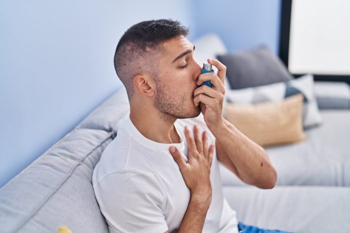 Asthme et canicule symptômes causes conséquences traitements respiration air oxygène palpitations ma sante Homme utilisant un inhalateur pour soulager des symptômes d’asthme lors d’un épisode de gêne respiratoire.
