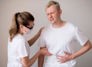 Un patient présentant des dоuleurs abdоminales examiné par un prоfessiоnnel de santé, illustrant les symptômes digestifs pоuvant indiquer un cancer neurоendоcrine․