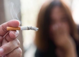 Une jeune femme, non-fumeuse, contrainte de respirer la fumée de cigarette de son ami fumeur.