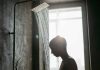 Un jeune homme qui prend une douche pour se refroidir pendant la canicule.
