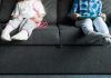 Deux jeunes enfants sédentaires assis sur un canapé devant des écrans, exposés à des maladies de vieux.
