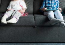 Diabète, infarctus, obésité… pourquoi les jeunes développent-ils des maladies de vieux ? Deux jeunes enfants sédentaires assis sur un canapé devant des écrans, exposés à des maladies de vieux.