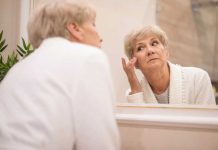 Double menton, bajoues, cou relâché : peut-on retendre sa peau sans chirurgie ? Une femme se regarde dans le miroir, à la recherche d’une solution pour retendre sa peau sans recourir à la chirurgie.