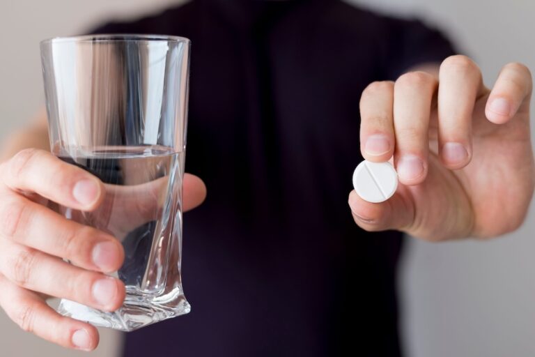 Un homme prenant de l'aspirine pour prévenir les complications d'une maladie cardiaque.