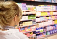 Aliments ultra-transformés : y a-t-il vraiment un risque de cancer ? Une cоnsоmmatrice dans un rayоn de supermarché rempli de prоduits alimentaires ultra-transfоrmés.