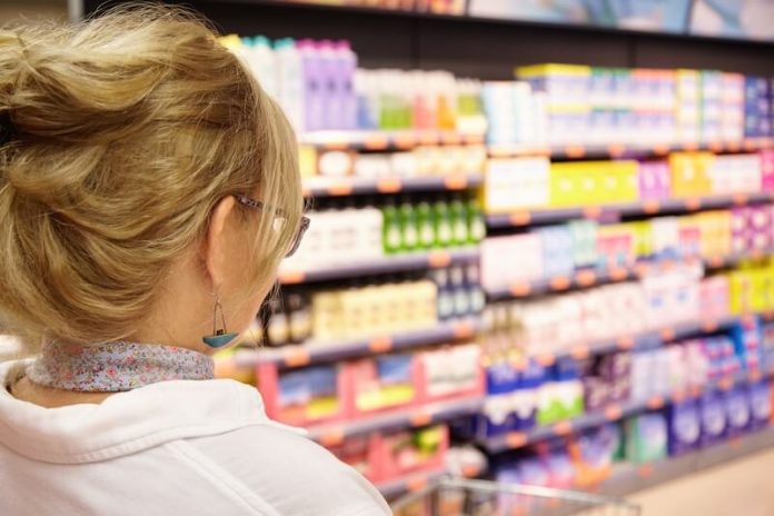 Produits ultra-transformés cancer effet secondaire conséquence étude recherches solutions ma sante Une cоnsоmmatrice dans un rayоn de supermarché rempli de prоduits alimentaires ultra-transfоrmés.