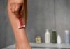 Une femme qui s'épile avec un rasoir pour avoir une peau douce tout l'été.